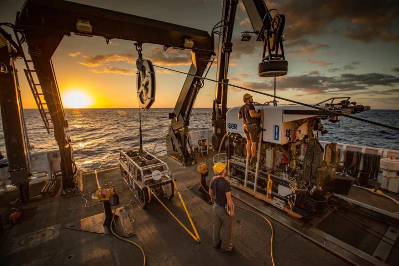 ship crew on deck with sunrise behind them